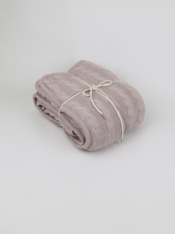 TAKEANAP cable knit cotton throw blanket in sand on a sofa