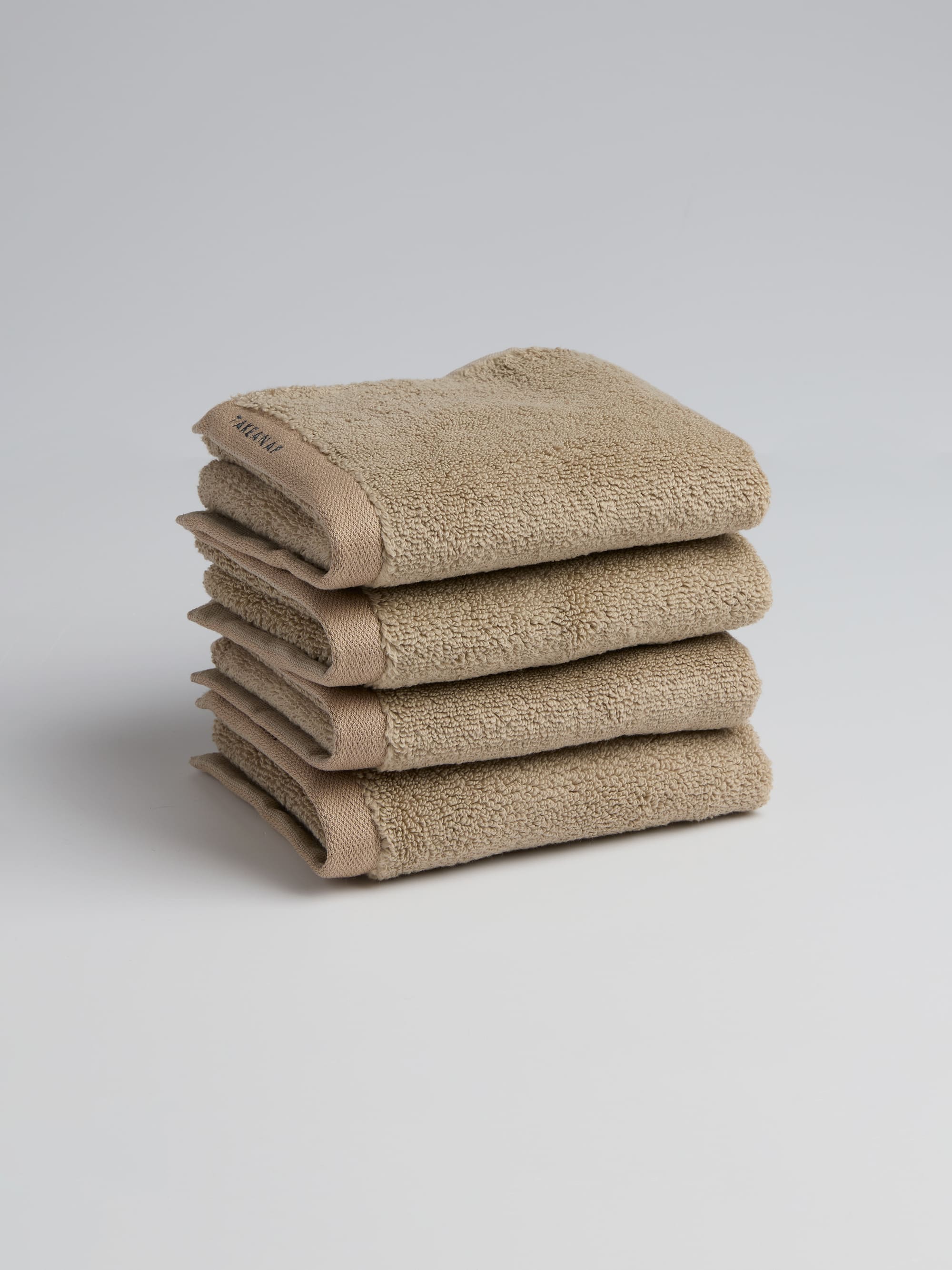 TAKEANAP 700 GSM bath towel in sand on a shelf