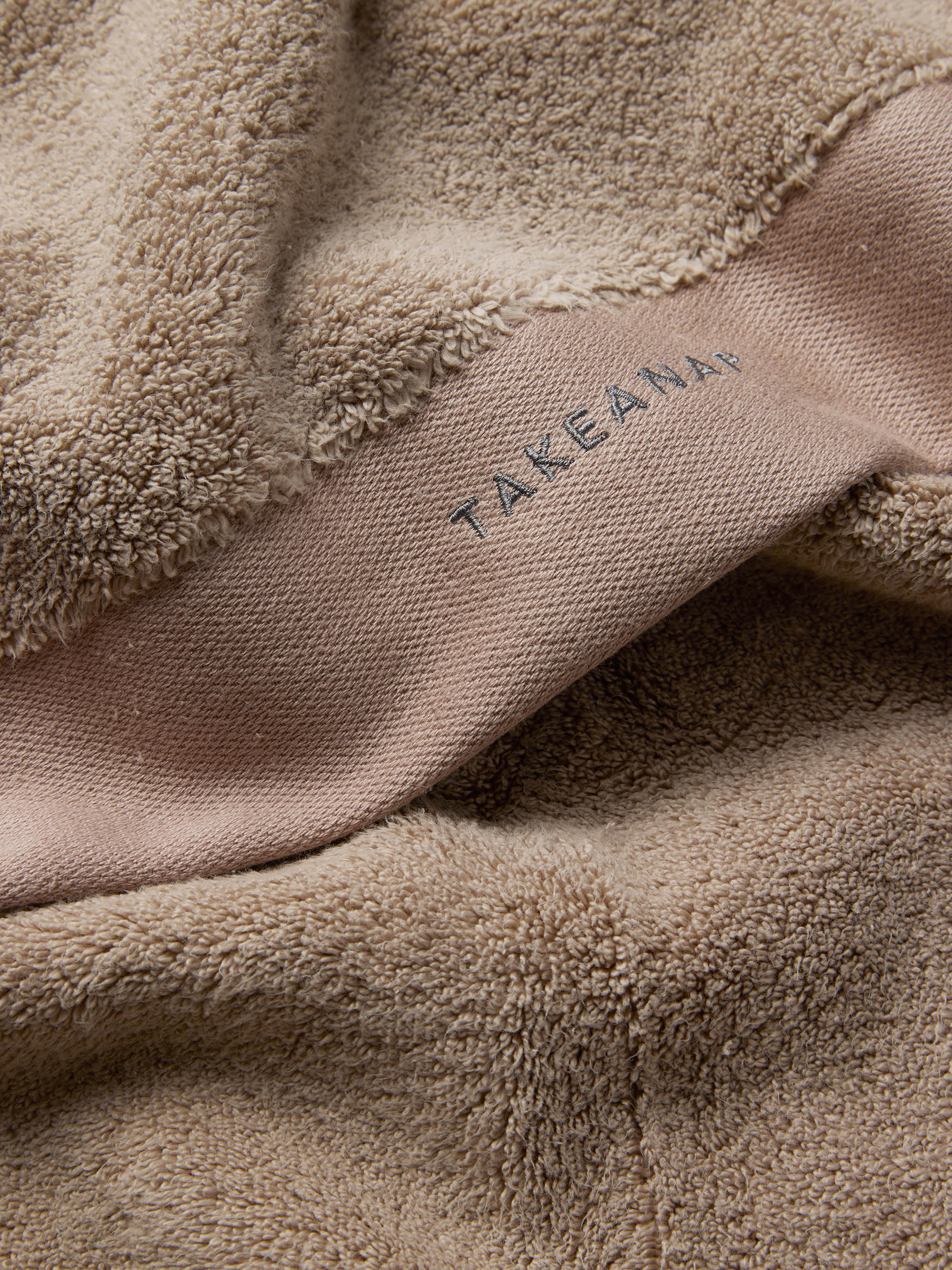 TAKEANAP 700 GSM bath towel in sand on a shelf