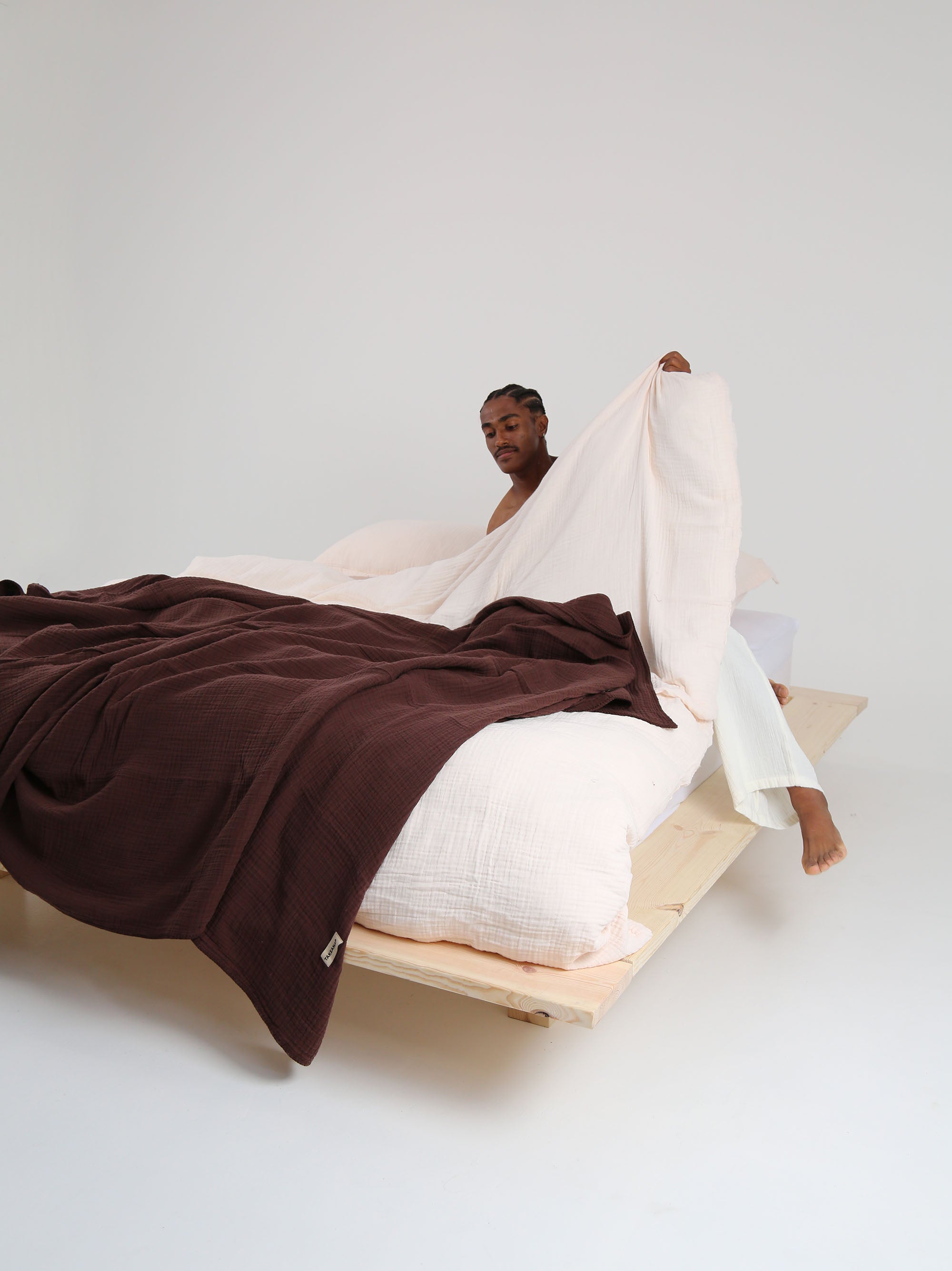 TAKEANAP Dream embroidered muslin coverlet in brownie on a bed
