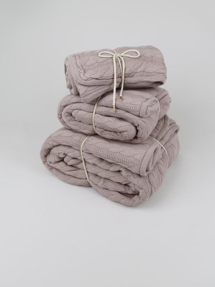 TAKEANAP cable knit cotton throw blanket in sand on a sofa