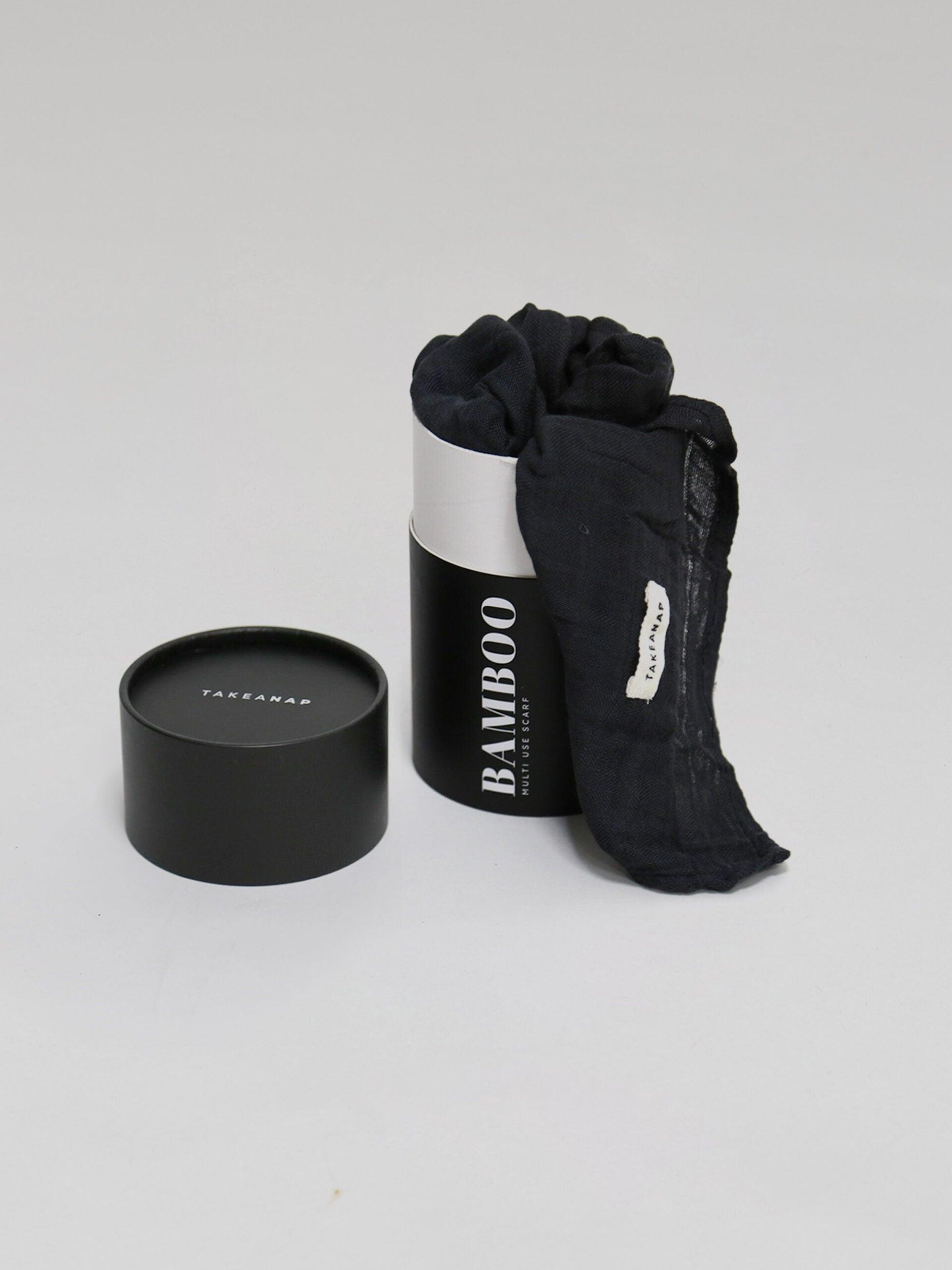 חיתול במבוק בצבע פחם נשפך מחוץ לאריזה שלו על רקע אפור בהיר בוהק