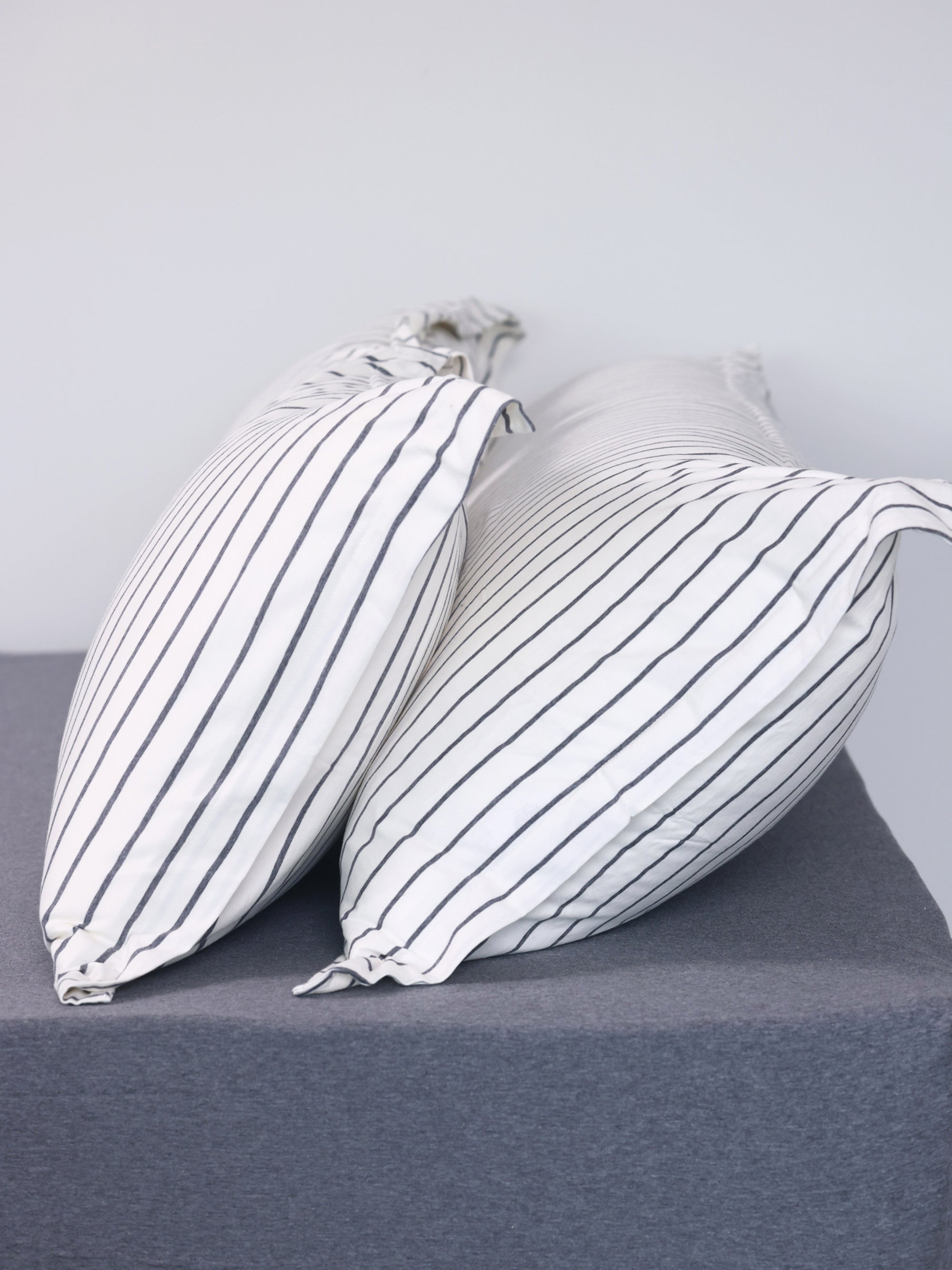 Hey youre on Duvet Set | Stripes product page. Image: Twin / purple stripes and 2 pillows with pillowcases on a white frame bed with jersey sheet 