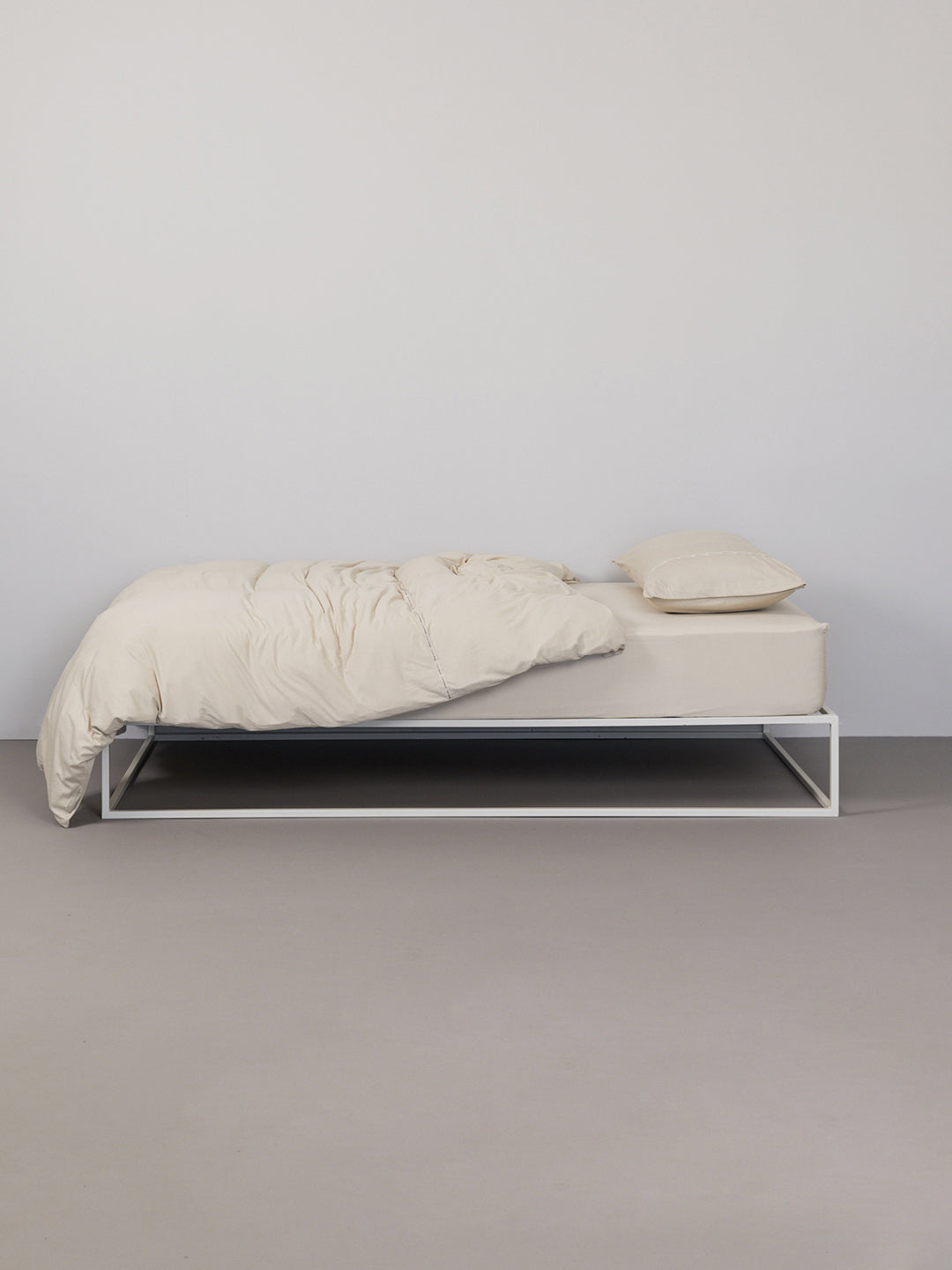 Hey you are on Fitted Bed Sheet | Basic product page. Image: Fitted Sheet on a white metal frame bed in a grey room