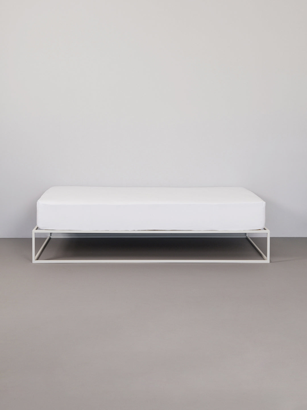 Hey you are on Fitted Bed Sheet | Basic product page. Image: Fitted white Sheet on a white metal  frame bed in a grey room 