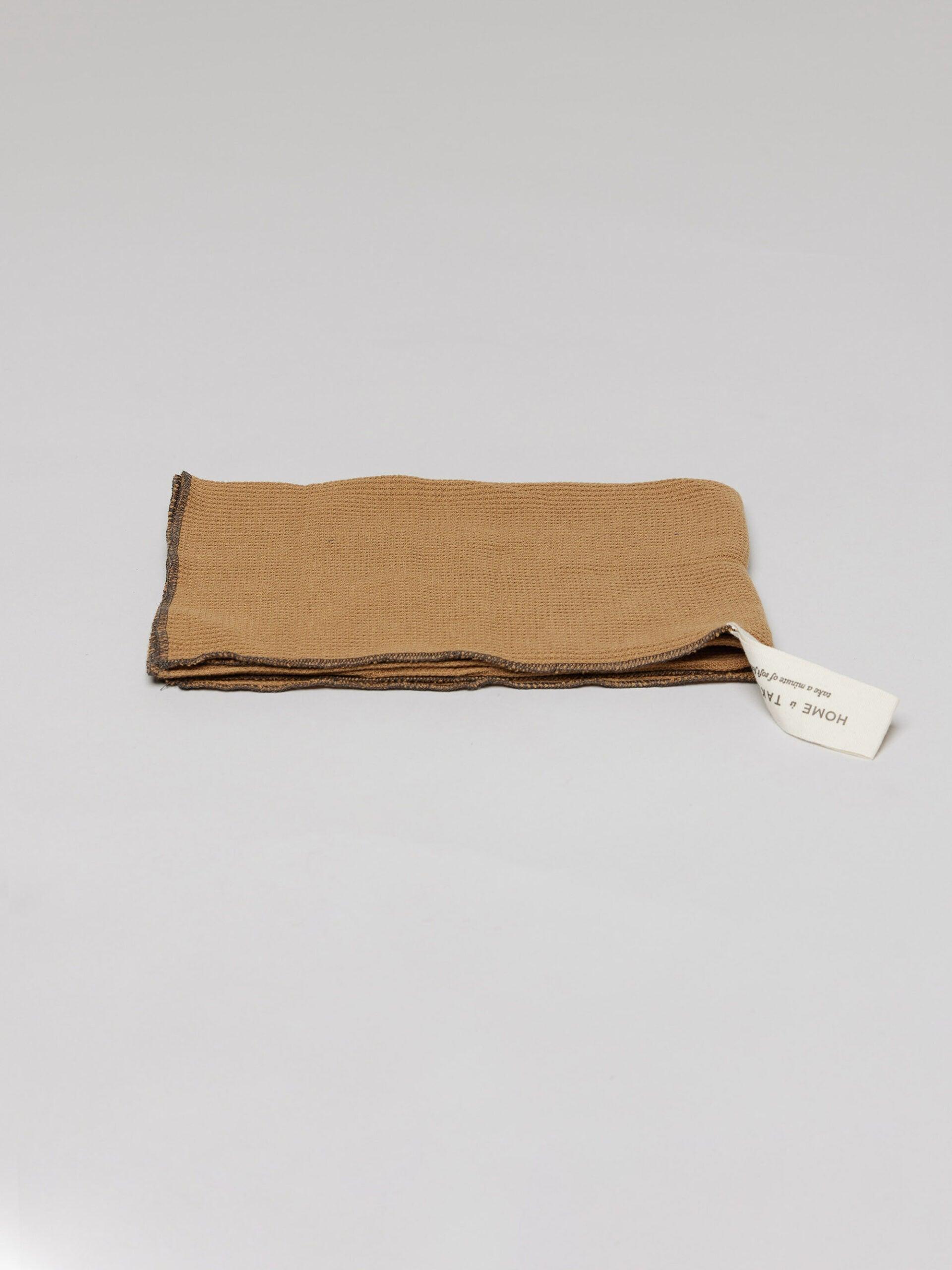 מגבת מטבח ג'קארד בצבע טופי על רקע אפור בהיר