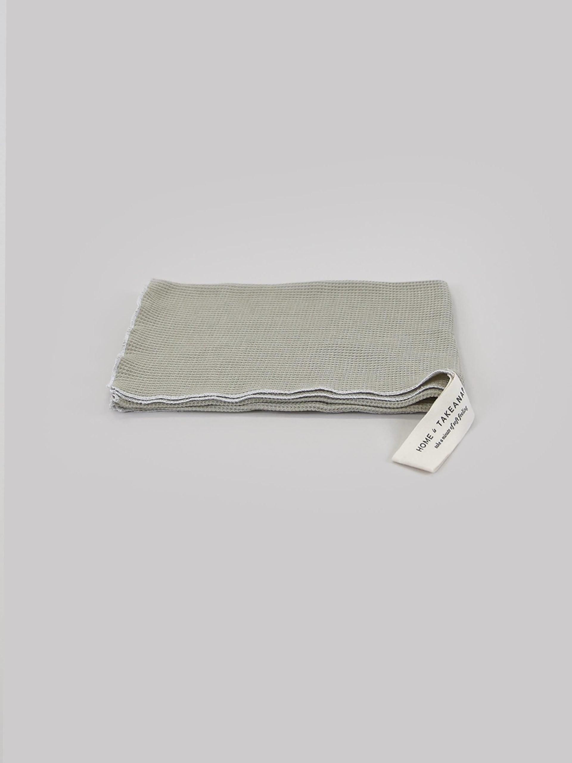 מגבת מטבח ג'קארד בצבע אקווה על רקע אפור בהיר