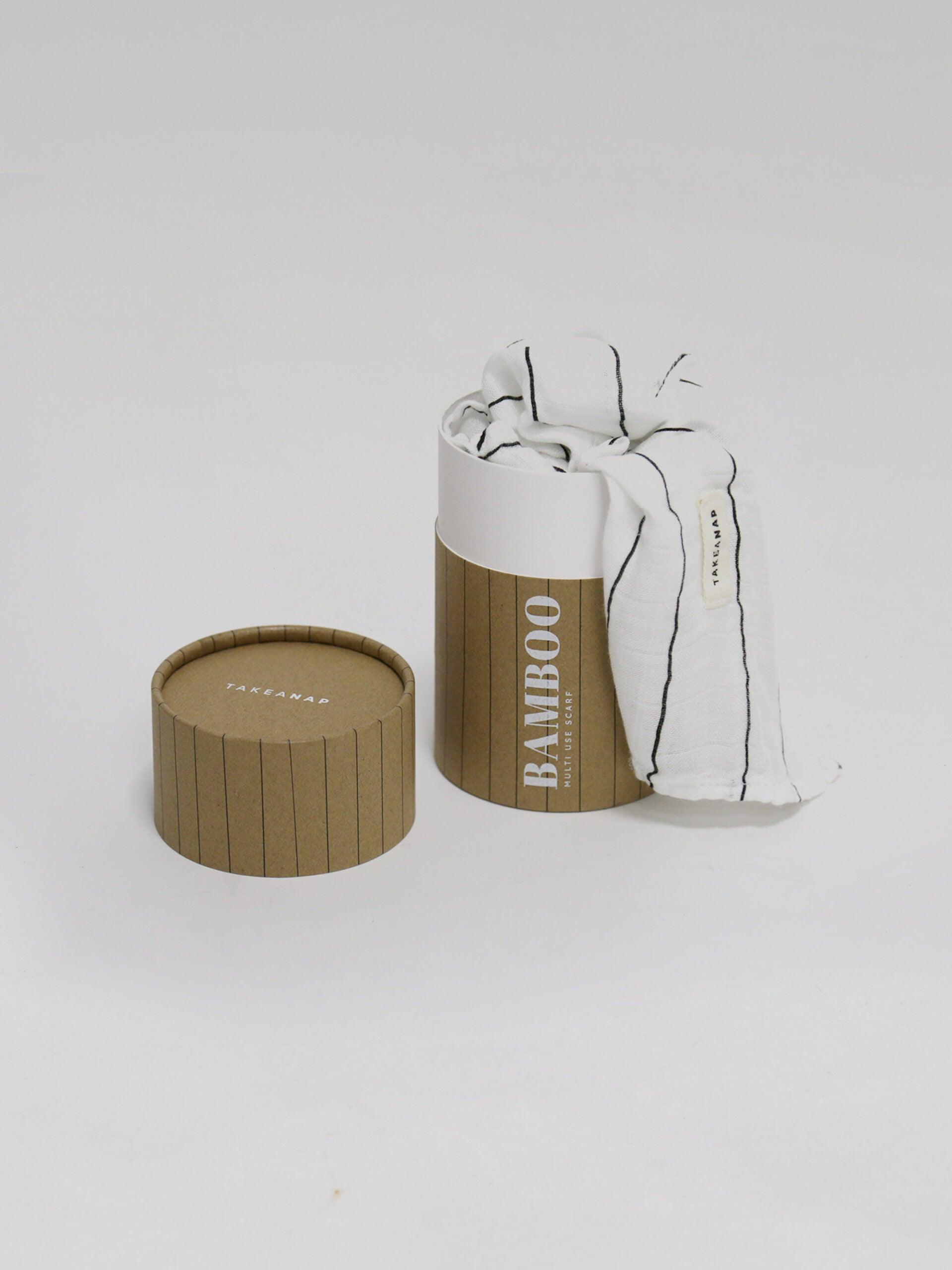 חיתול במבוק בצבע פסים שחור לבן נשפך מחוץ לאריזה שלו על רקע אפור בהיר בוהק